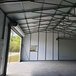 30x50 Steel Building, with wainscot siding Red and cream With two white garage doors Probuilt structures robin sheds Steel buildings for sale in central florida citrus county and marion county Three garage doors and windows plus walk door interior pictures