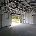 30x50 Steel Building, with wainscot siding Red and cream With two white garage doors Probuilt structures robin sheds Steel buildings for sale in central florida citrus county and marion county Three garage doors one walk door interior pictures storage building